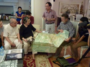 Bob Hall uses a topographical map to show a Hanoi family where their brother died in battle in an ambush set by New Zealand infantrymen in the Nui Dinhs. A photograph of their brother, held by his sister, was captured after the ambush. In this case, the captured photograph and details of the contact in which it was captured, have allowed the family to attempt to recover their brother’s remains from the ambush site. A six-figure grid reference in the contact report records the best available information about the location of the contact.