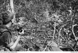 A patrol commander of 6RAR calls in ‘Contact! Wait out’ on the patrol’s AN/PRC-25 radio set.