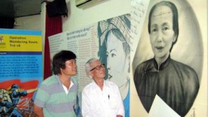 Le Hang and his son, admiring the portrait of his mother, Phan Thi Vu. The portrait was rescued from a burning building by an Australian adviser. Le Hang was overjoyed to receive the portrait after its lengthy ‘holiday’ in Australia.